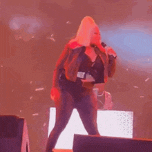 a woman is singing into a microphone on a stage at a concert .