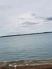 a large body of water with a cloudy sky