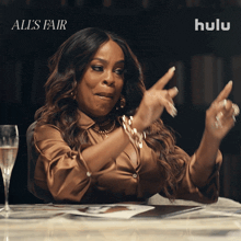 a woman sitting at a table with a glass of champagne and hulu written on the bottom