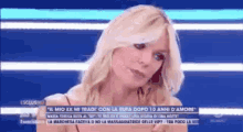 a woman with blonde hair is talking on a tv show .