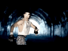 a man in a white tank top is running in a tunnel