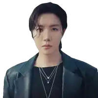 a young man wearing a black jacket and a necklace looks at the camera