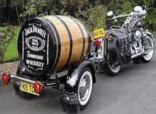 a jack daniel 's barrel is attached to a motorcycle trailer