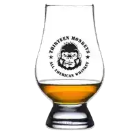 a glass of thirteen monkeys all american whiskey with a gorilla on it