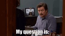 a man sitting at a desk with the words my question is