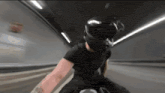 a person wearing a helmet is riding a motorcycle in a tunnel .