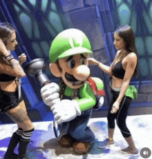 two women are standing next to a statue of luigi from super mario holding a flashlight .