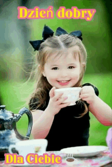 a little girl is sitting at a table drinking a cup of tea .