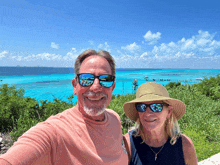 a man and a woman wearing sunglasses and hats pose for a photo