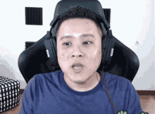 a man wearing headphones is sitting in a gaming chair