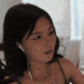 a close up of a woman wearing headphones and looking at the camera .