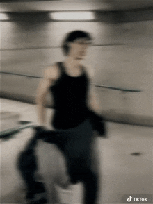 a blurry picture of a man in a black tank top and black jeans