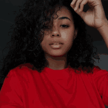 a woman with curly hair wearing a red shirt