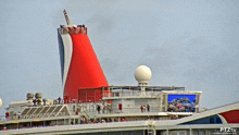 a large cruise ship with a large red cone on top