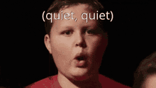 a boy in a red shirt with the words quiet quiet written on his face