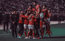 a group of soccer players wearing red and white jerseys with the number 6 on them