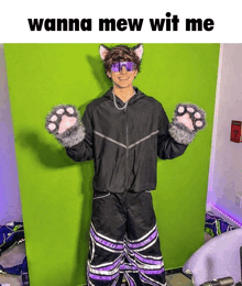 a man in a cat costume is standing in front of a green screen with the caption wanna mew wit me