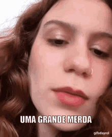 a close up of a woman 's face with the words uma grande merda above her