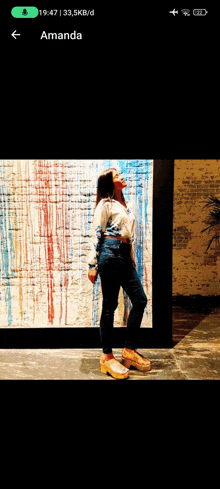 a woman standing in front of a colorful wall with the name amanda at the top