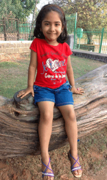 a young girl wearing a red shirt that says je t'aime