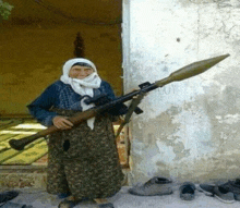 an elderly woman is holding a rifle and a rocket