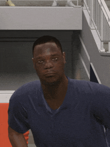 a man in a blue shirt is standing in front of a staircase