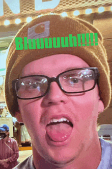 a man wearing glasses and a beanie is making a funny face with the words bluuuuh !!! behind him