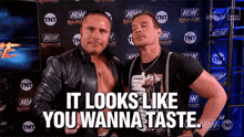 two wrestlers are posing for a picture and one of them is saying `` it looks like you wanna taste '' .