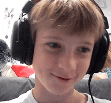 a young boy is wearing headphones and smiling for the camera