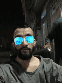 a man with a beard wearing a pair of blue sunglasses with b612 written on the bottom right