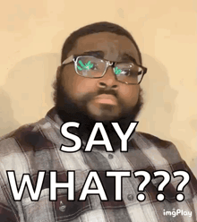 a man with glasses and a beard is wearing a plaid shirt and saying say what ?