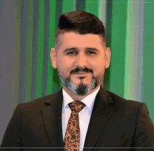 a man with a beard wearing a suit and tie poses for a picture