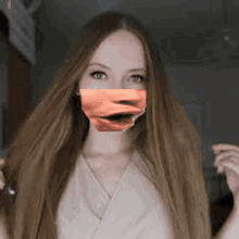 a woman with long hair is wearing a mask with a face on it .