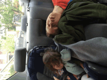 a man and a child are sleeping in a car