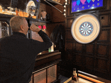 a man is playing a game of darts with a dart board that says ' lucky strike ' on it