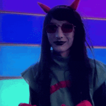 a woman wearing a devil costume and sunglasses