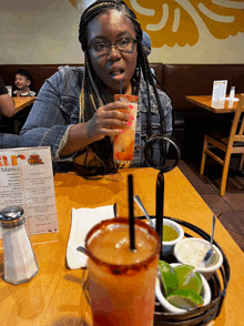 a woman sits at a table in front of a menu that says ' menu ' on it