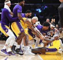 a group of basketball players in purple and yellow shorts with the number 14 on the back