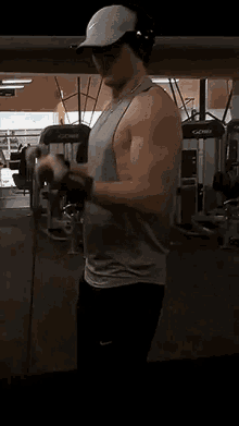 a man is standing in a gym holding a rope .