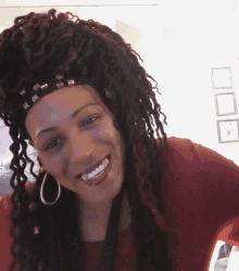 a woman with dreadlocks is smiling and wearing a headband that says ' aa ' on it