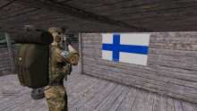 a soldier stands in front of a finland flag on a wooden wall