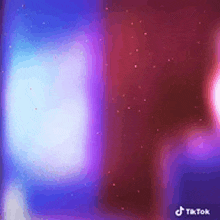 a blue and purple light is shining on a red and purple background .