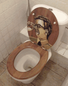 a toilet with a painting of a man on the seat