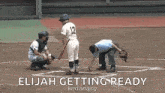 a baseball player with the number 12 on his jersey is getting ready to bat while a referee looks on .