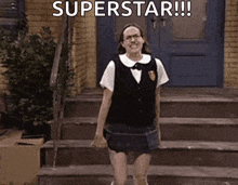 a woman in a school uniform is standing on a set of stairs with the words `` superstar '' written above her .