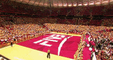 a large crowd of people are watching a basketball game in a stadium with a large coca cola logo on the court