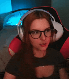 a woman wearing glasses and headphones covering her mouth with her hand