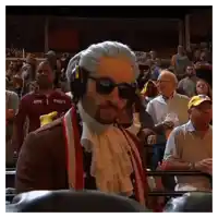a man wearing a wig and sunglasses stands in a crowd
