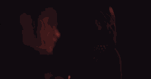 a man and a woman are standing next to each other in the dark .