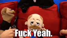 a puppet is sitting on a red couch with the words fuck yeah